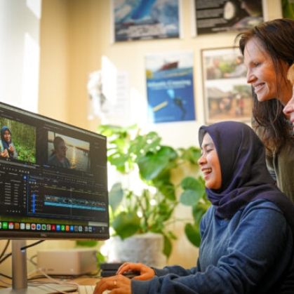Student and advisors looking at a video editing program